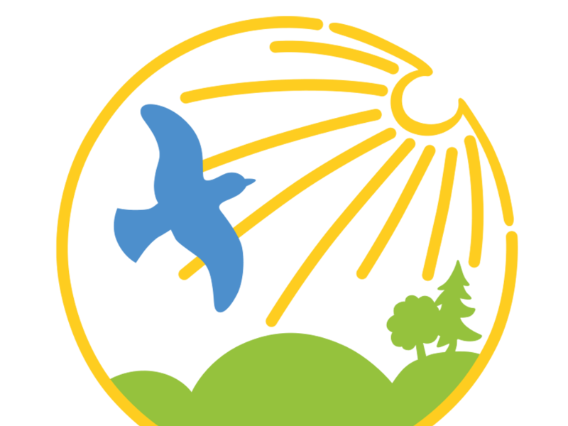 Ein Logo zeigt einen gelben Kreis mit einem blauen Vogel, Sonnenschein, grüne Hügel und Bäume, sowie dem Text "Das Lebensende in Würde gestalten" darunter.