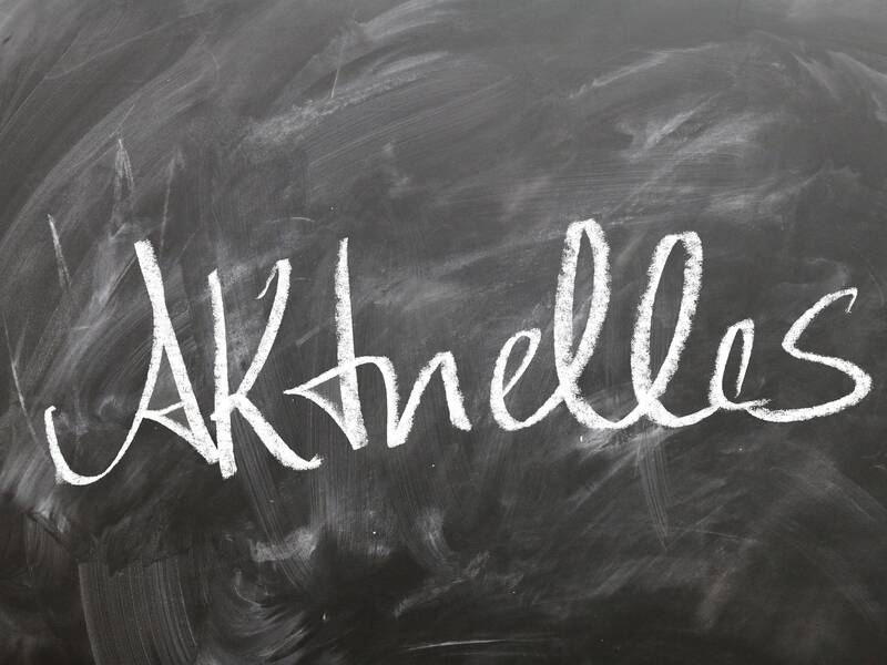 Schiefertafel auf der mit Kreide "Aktuelles" geschrieben steht